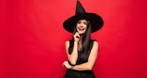 A smiling woman dressed up as a witch